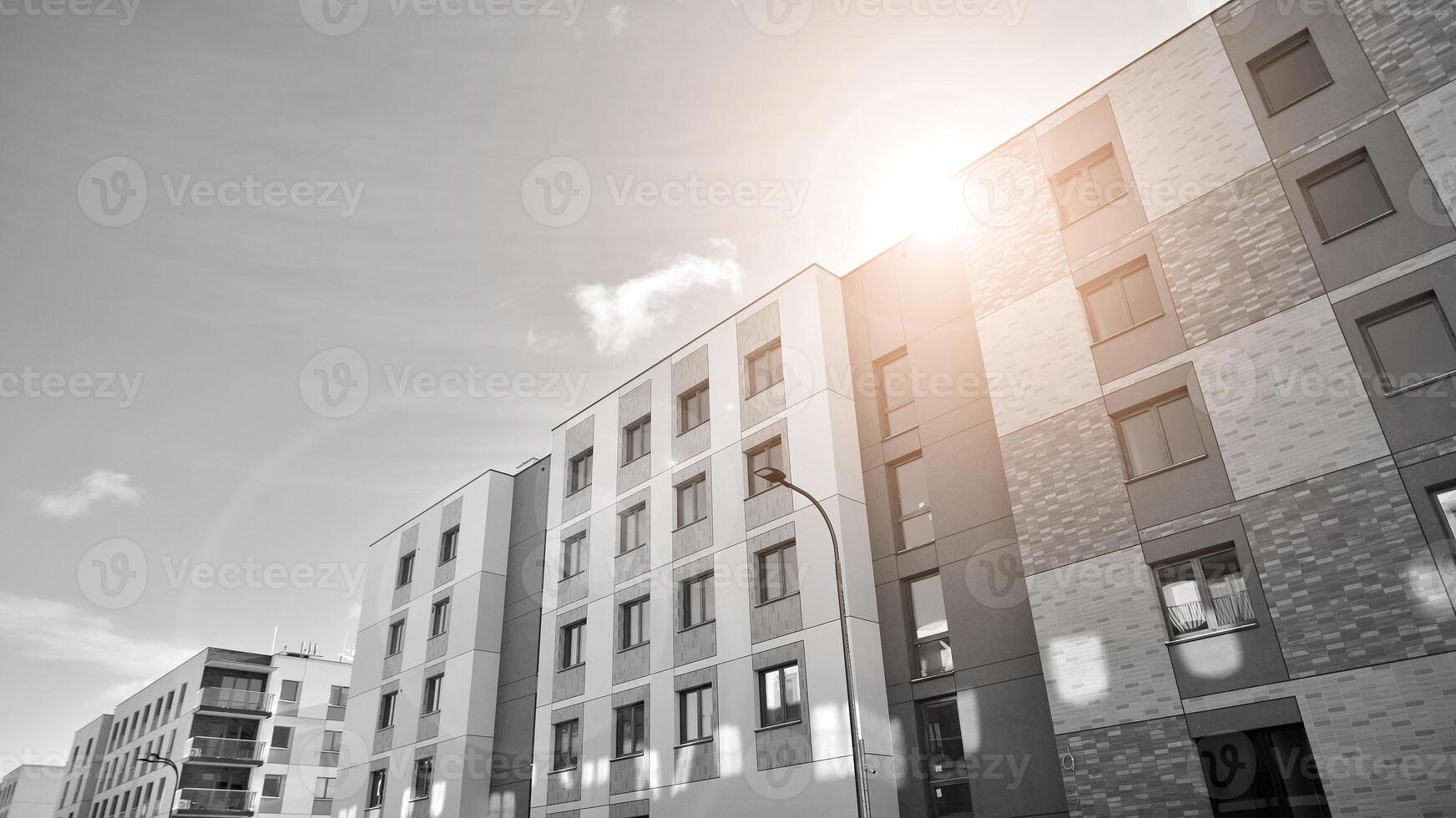 Fragment of the building's facade with windows and balconies. Modern apartment buildings on a sunny day. Facade of a modern residential building. Black and white. photo