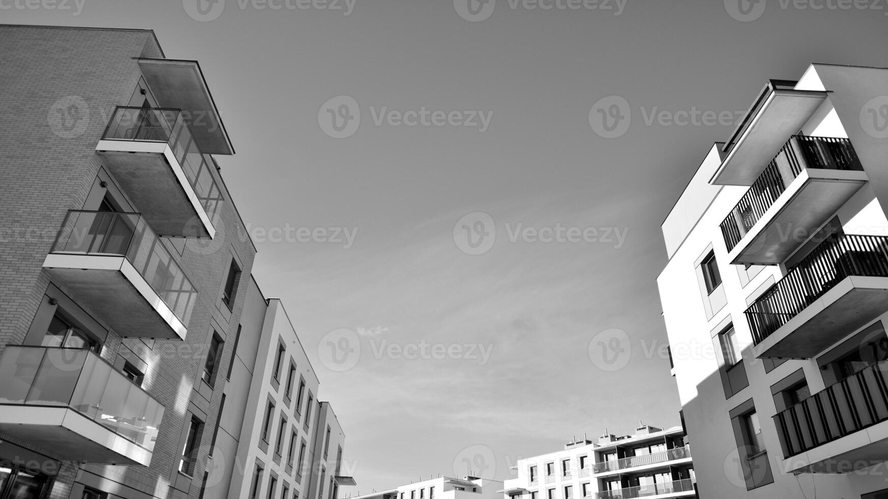 Fragment of the building's facade with windows and balconies. Modern apartment buildings on a sunny day. Facade of a modern residential building. Black and white. photo