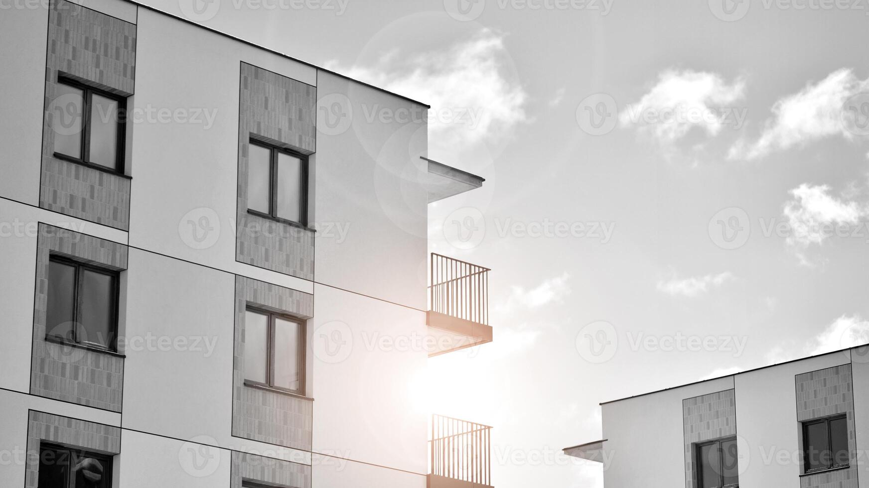 Fragment of the building's facade with windows and balconies. Modern apartment buildings on a sunny day. Facade of a modern residential building. Black and white. photo