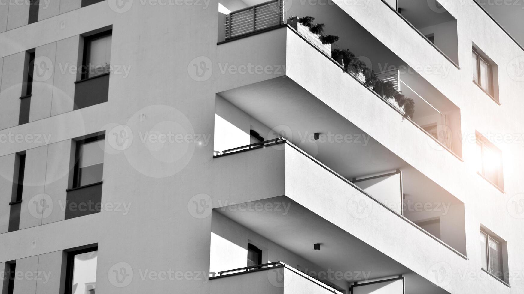 Fragment of the building's facade with windows and balconies. Modern apartment buildings on a sunny day. Facade of a modern residential building. Black and white. photo
