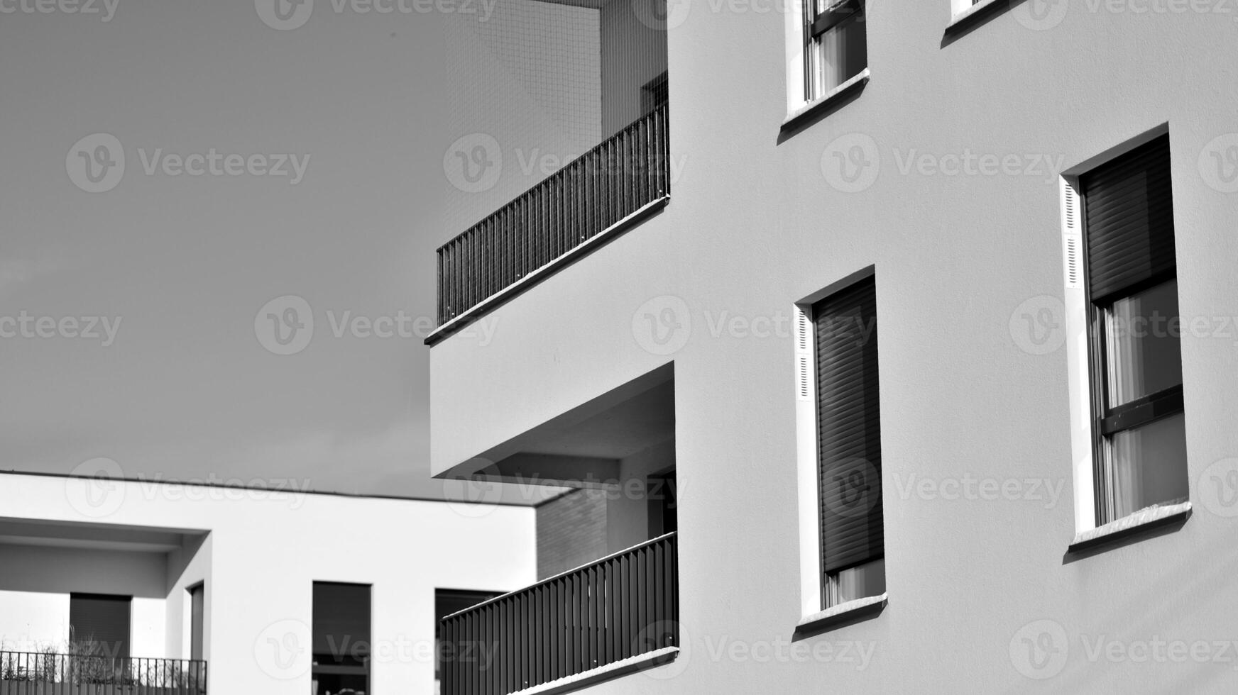 Fragment of the building's facade with windows and balconies. Modern apartment buildings on a sunny day. Facade of a modern residential building. Black and white. photo