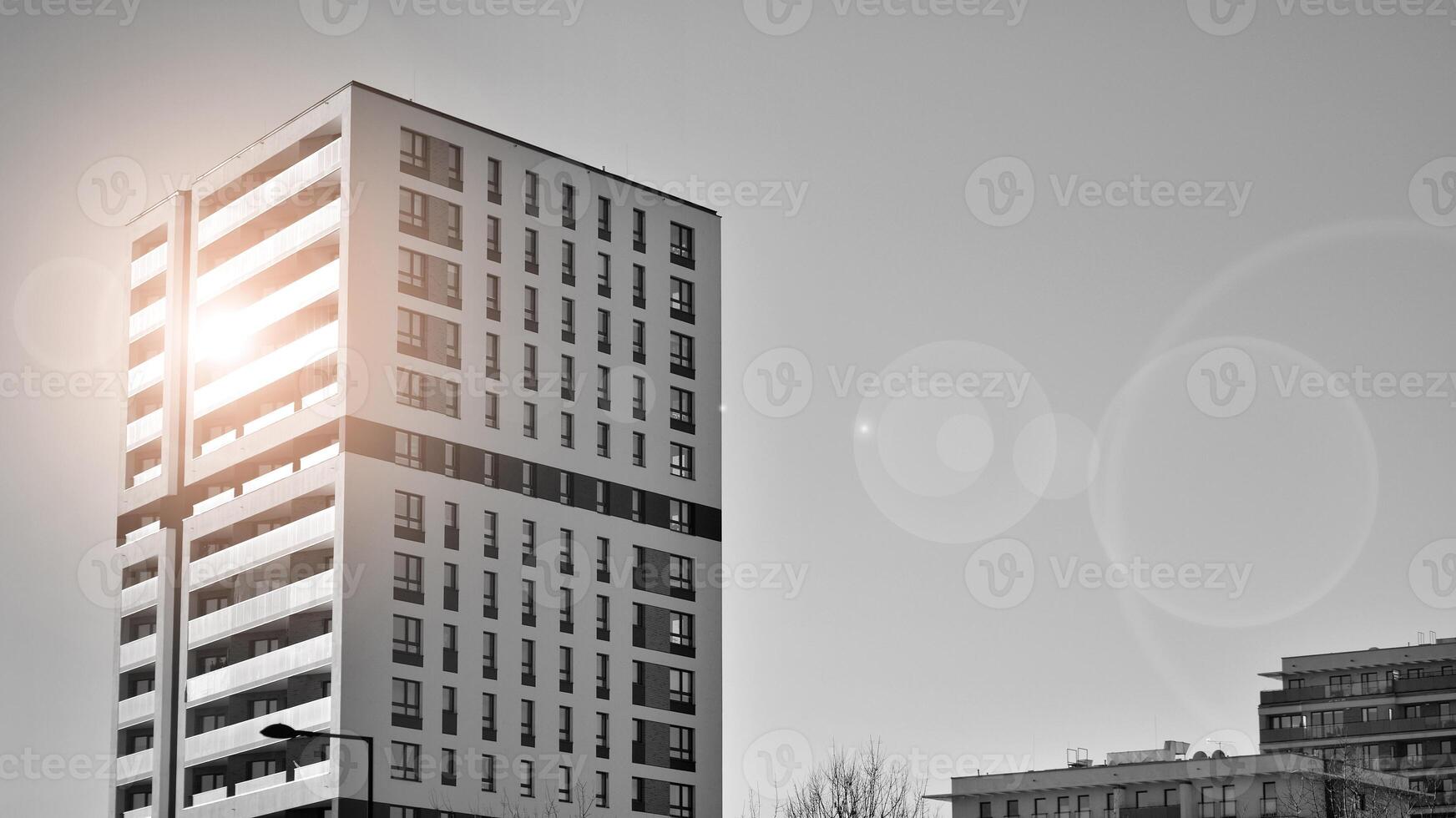 Fragment of the building's facade with windows and balconies. Modern apartment buildings on a sunny day. Facade of a modern residential building. Black and white. photo