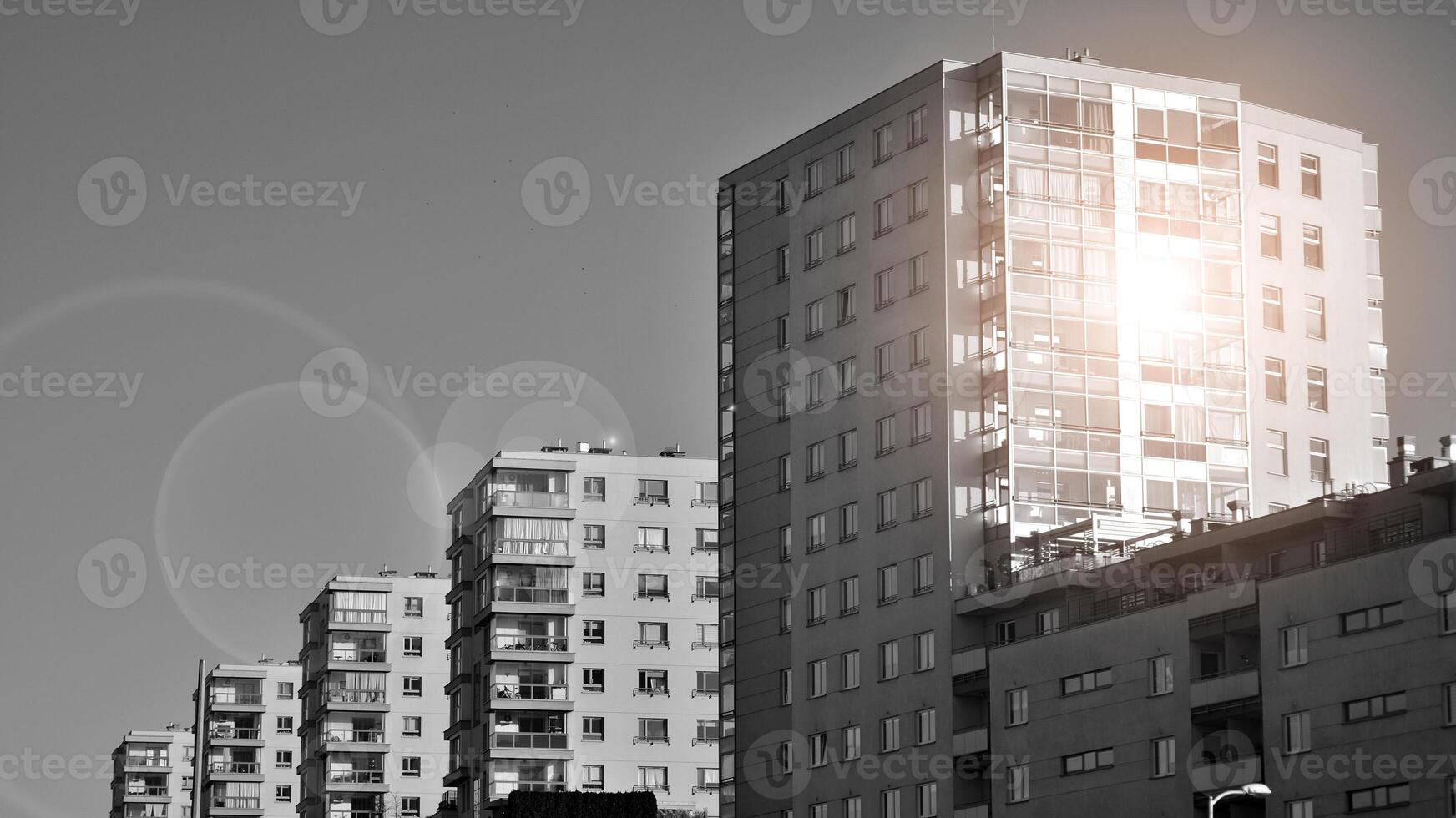 Fragment of the building's facade with windows and balconies. Modern apartment buildings on a sunny day. Facade of a modern residential building. Black and white. photo