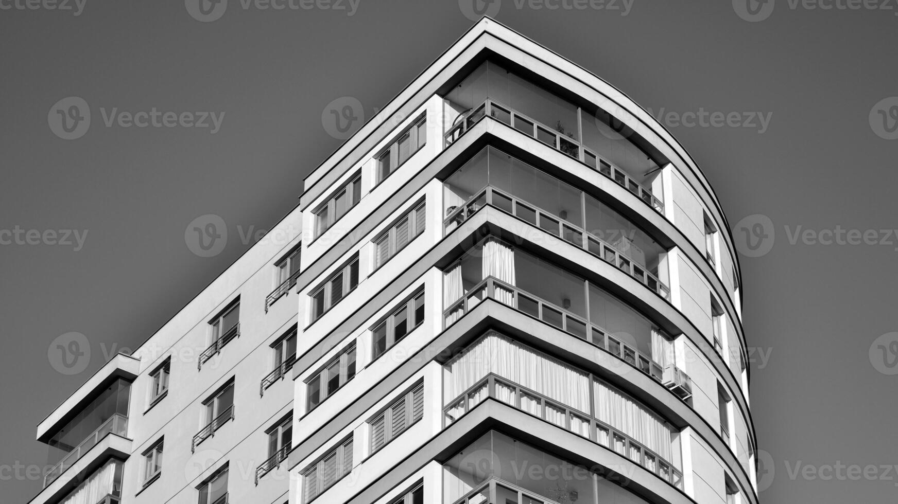 Fragment of the building's facade with windows and balconies. Modern apartment buildings on a sunny day. Facade of a modern residential building. Black and white. photo