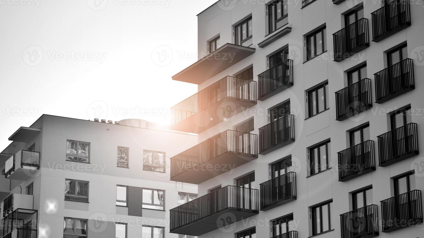 Fragment of the building's facade with windows and balconies. Modern apartment buildings on a sunny day. Facade of a modern residential building. Black and white. photo
