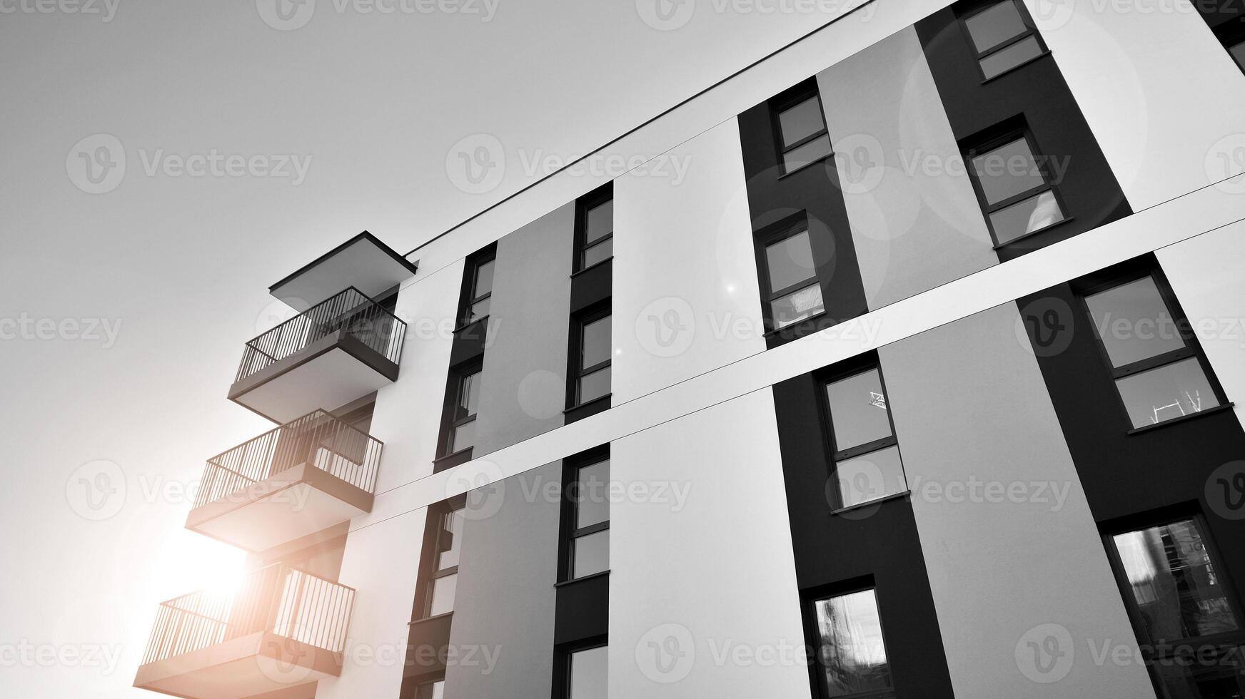 Fragment of the building's facade with windows and balconies. Modern apartment buildings on a sunny day. Facade of a modern residential building. Black and white. photo