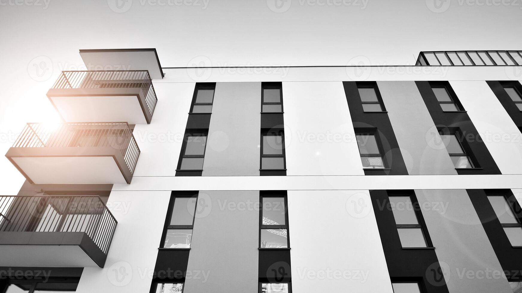 Fragment of the building's facade with windows and balconies. Modern apartment buildings on a sunny day. Facade of a modern residential building. Black and white. photo