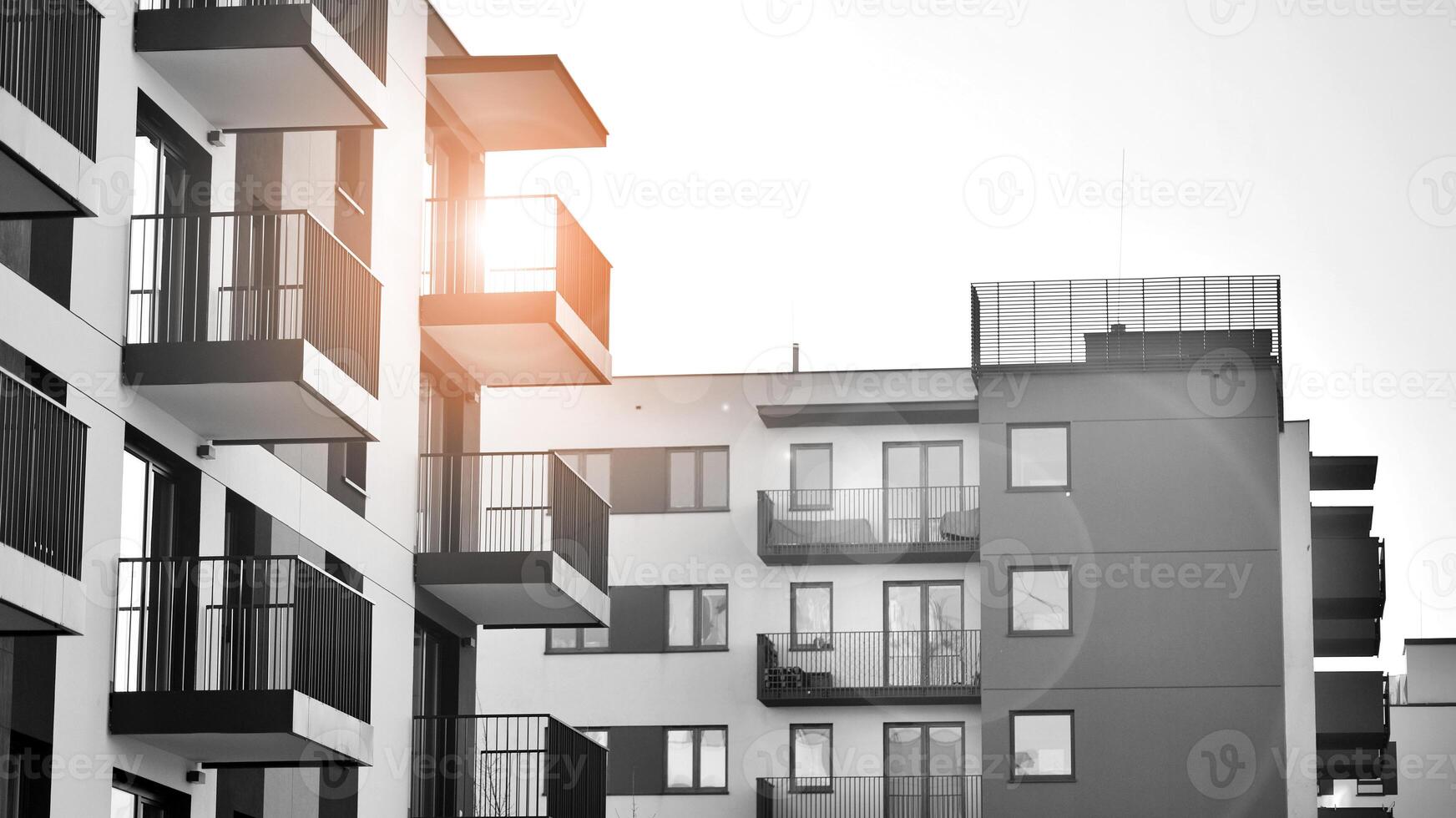 Fragment of the building's facade with windows and balconies. Modern apartment buildings on a sunny day. Facade of a modern residential building. Black and white. photo