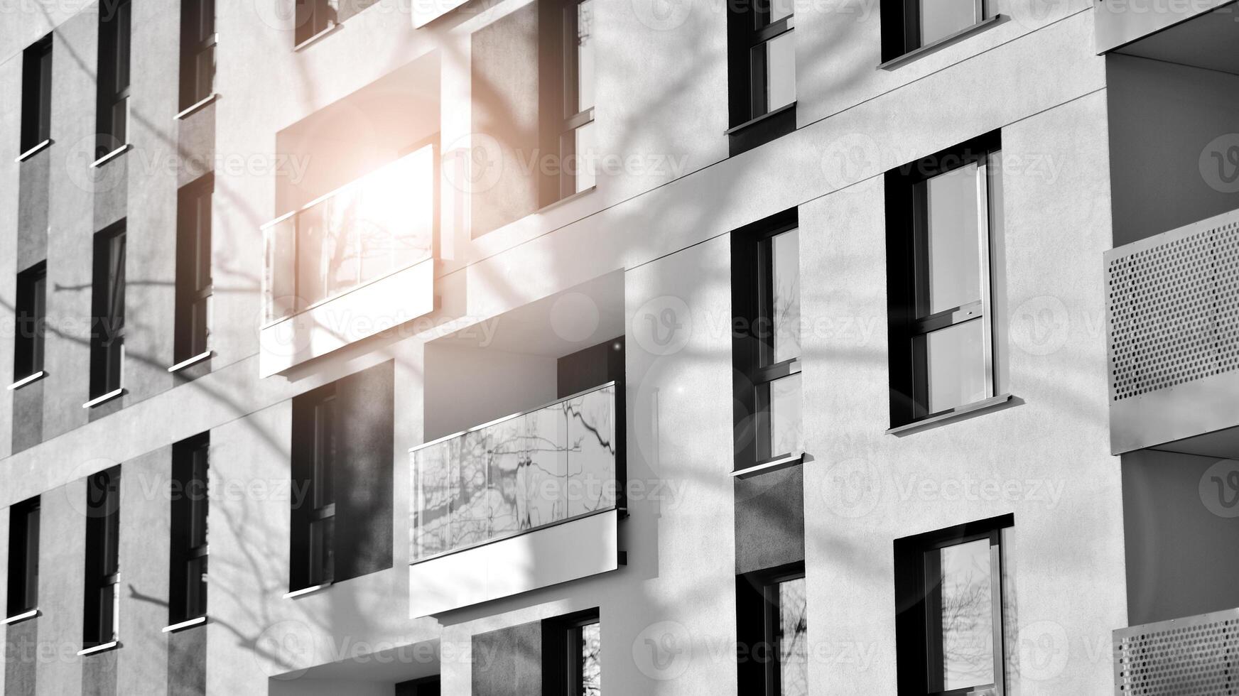 Fragment of the building's facade with windows and balconies. Modern apartment buildings on a sunny day. Facade of a modern residential building. Black and white. photo