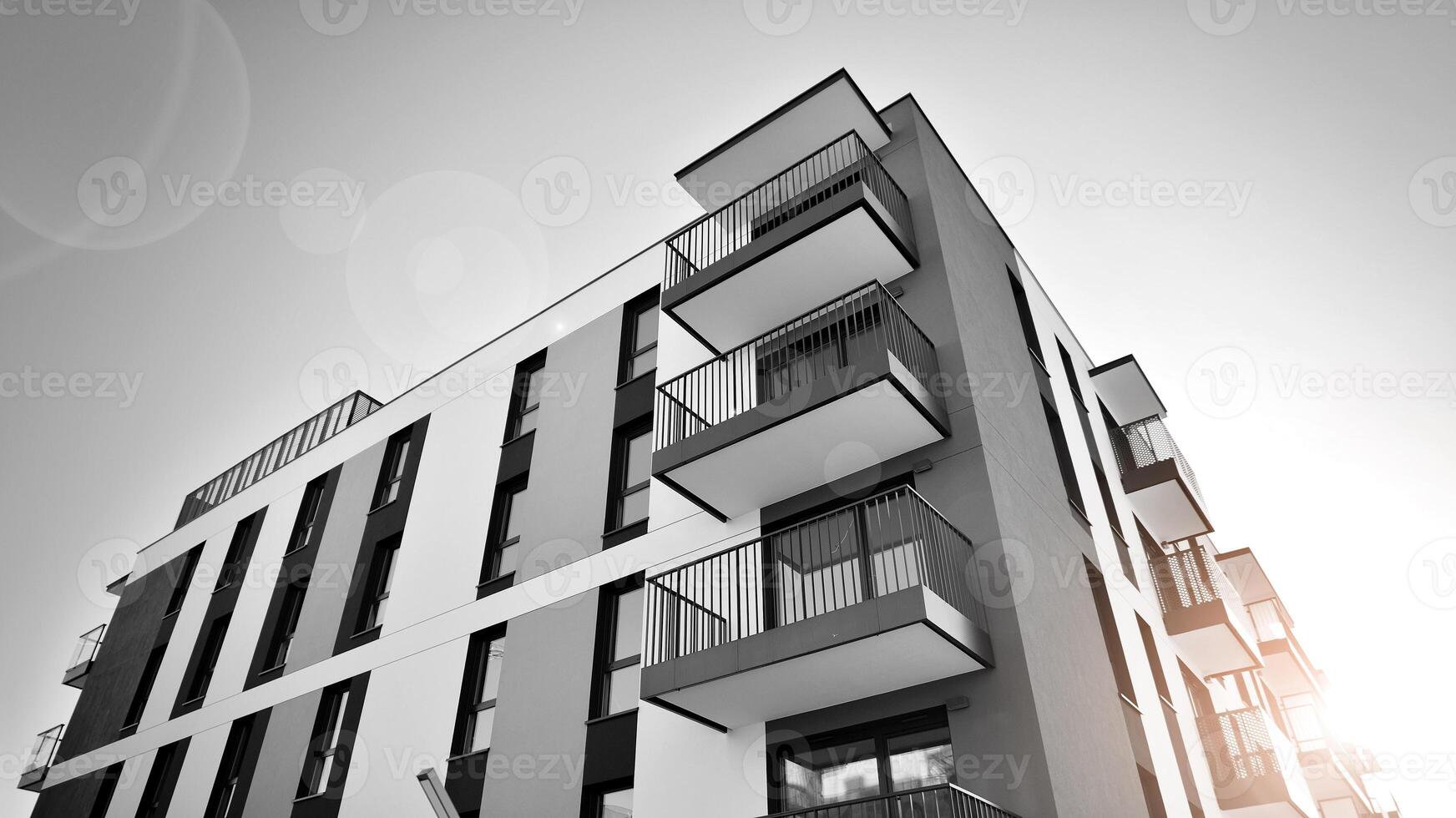 Fragment of the building's facade with windows and balconies. Modern apartment buildings on a sunny day. Facade of a modern residential building. Black and white. photo