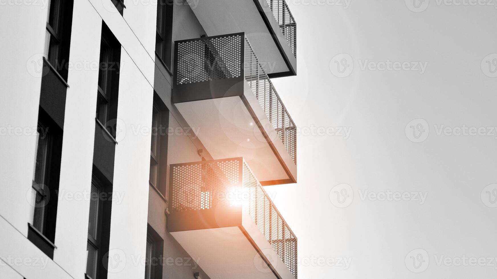 Fragment of the building's facade with windows and balconies. Modern apartment buildings on a sunny day. Facade of a modern residential building. Black and white. photo