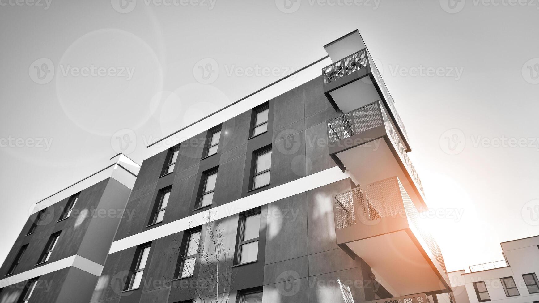 Fragment of a facade of a building with windows and balconies. Modern apartment buildings on a sunny day. Facade of a modern apartment building. Black and white. photo