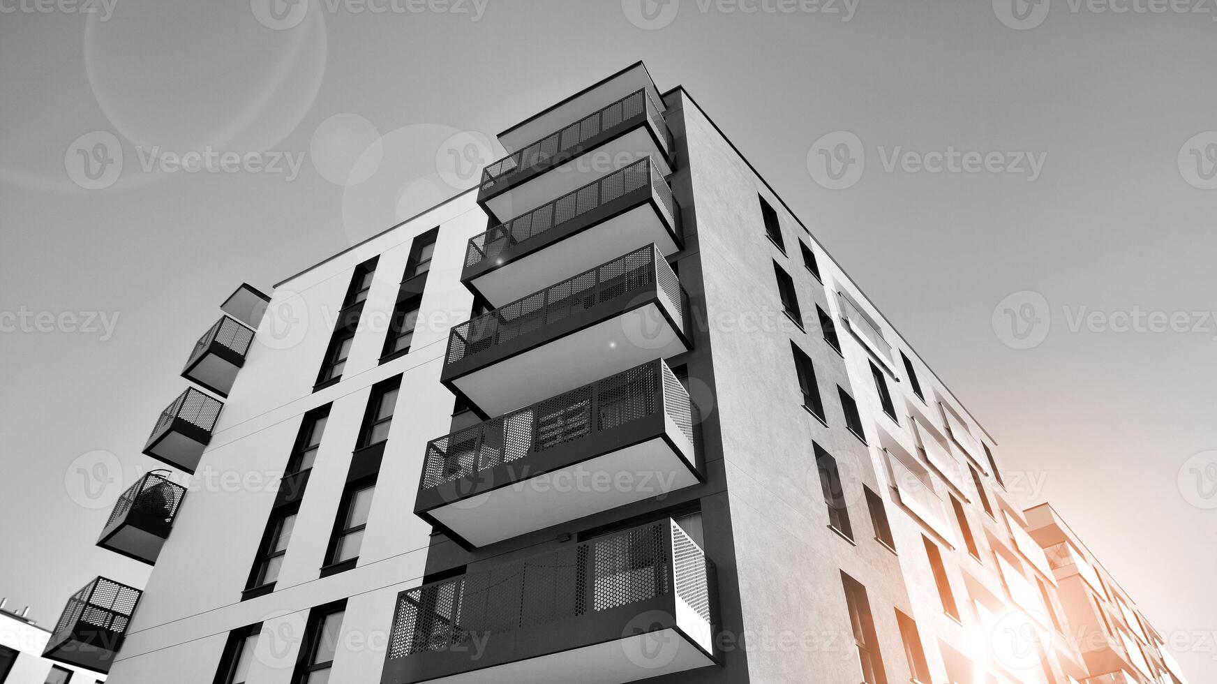 Fragment of a facade of a building with windows and balconies. Modern apartment buildings on a sunny day. Facade of a modern apartment building. Black and white. photo