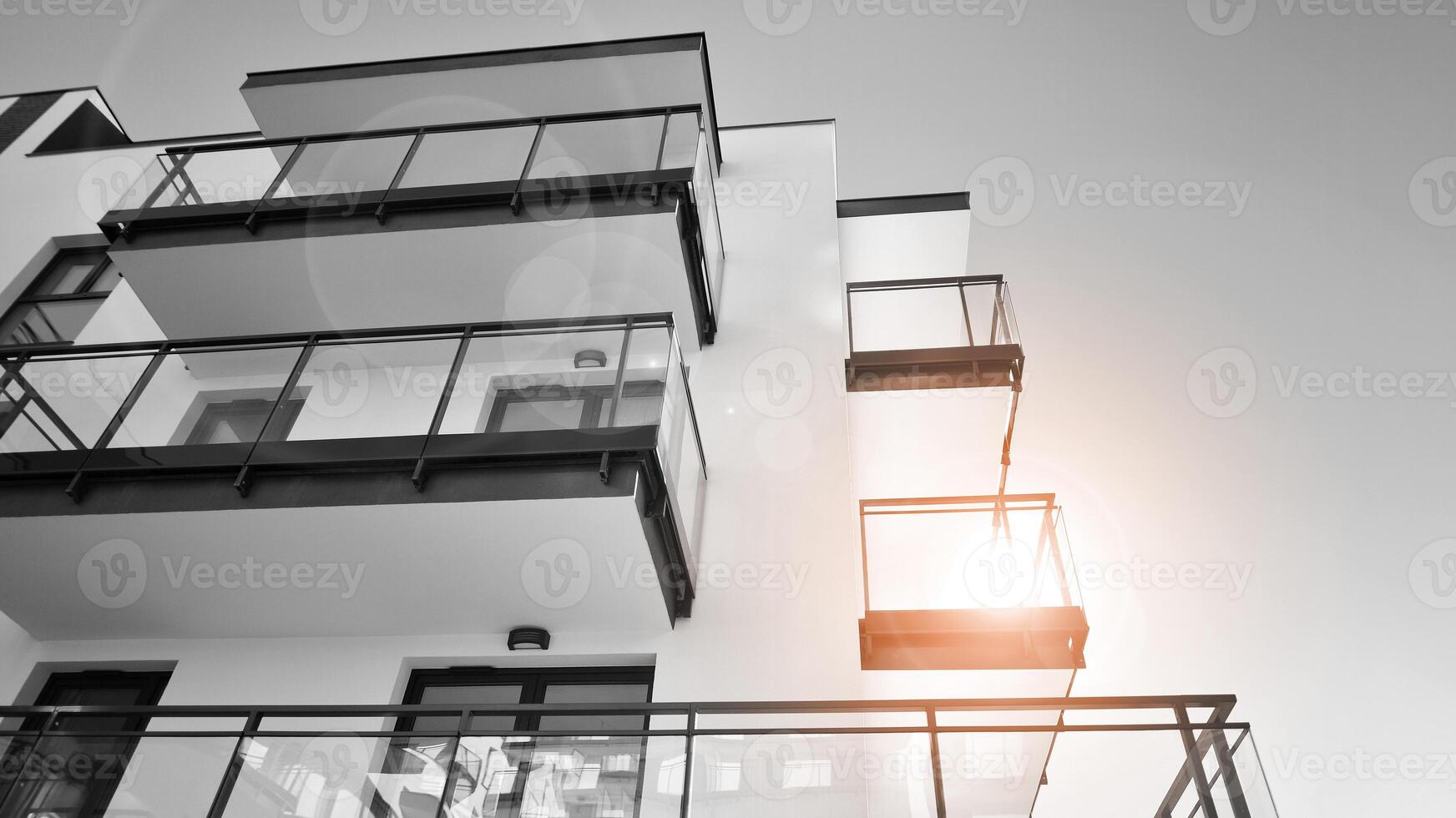 Fragment of a facade of a building with windows and balconies. Modern apartment buildings on a sunny day. Facade of a modern apartment building. Black and white. photo