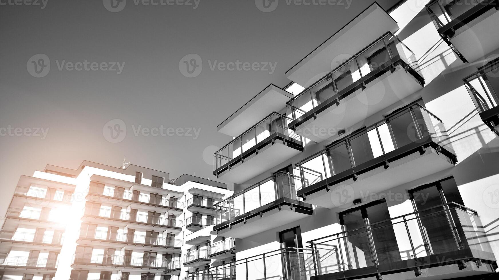 Fragment of a facade of a building with windows and balconies. Modern apartment buildings on a sunny day. Facade of a modern apartment building. Black and white. photo