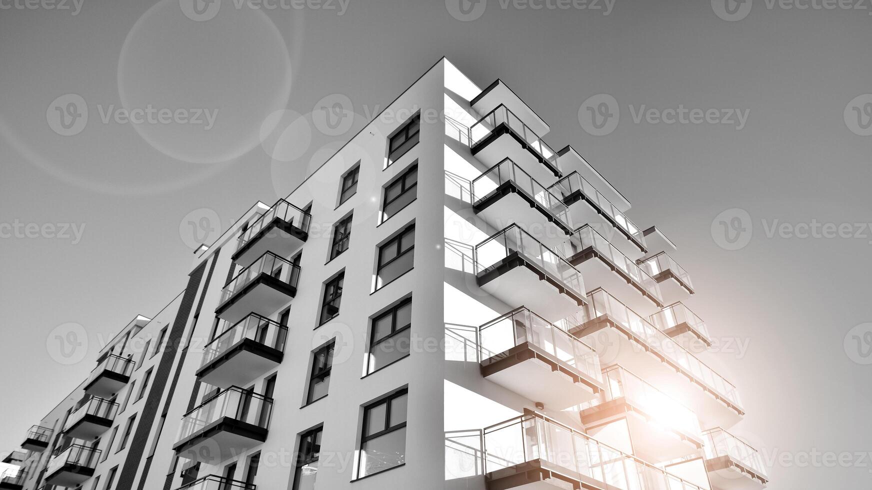 Fragment of a facade of a building with windows and balconies. Modern apartment buildings on a sunny day. Facade of a modern apartment building. Black and white. photo