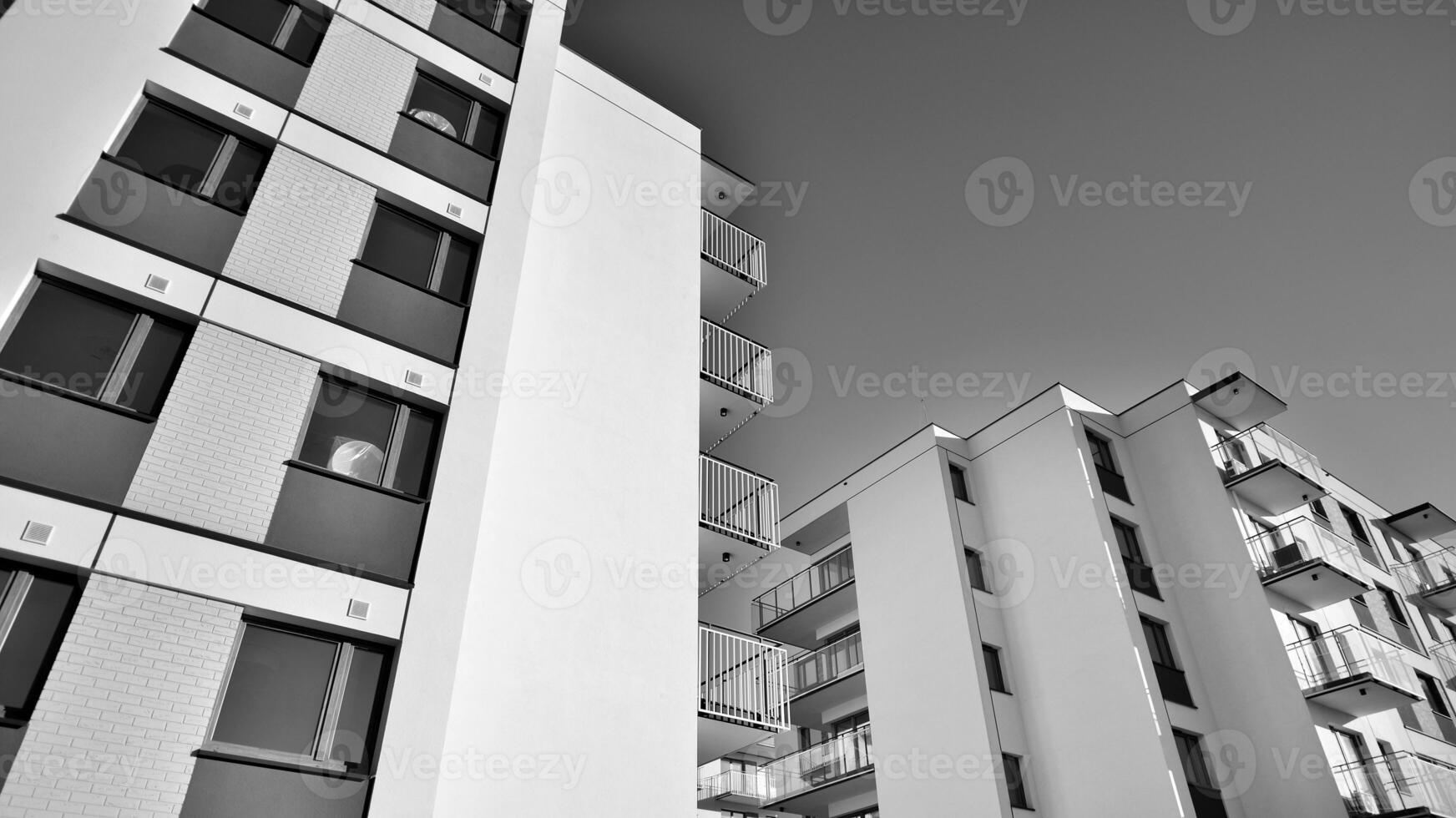 Fragment of a facade of a building with windows and balconies. Modern apartment buildings on a sunny day. Facade of a modern apartment building. Black and white. photo