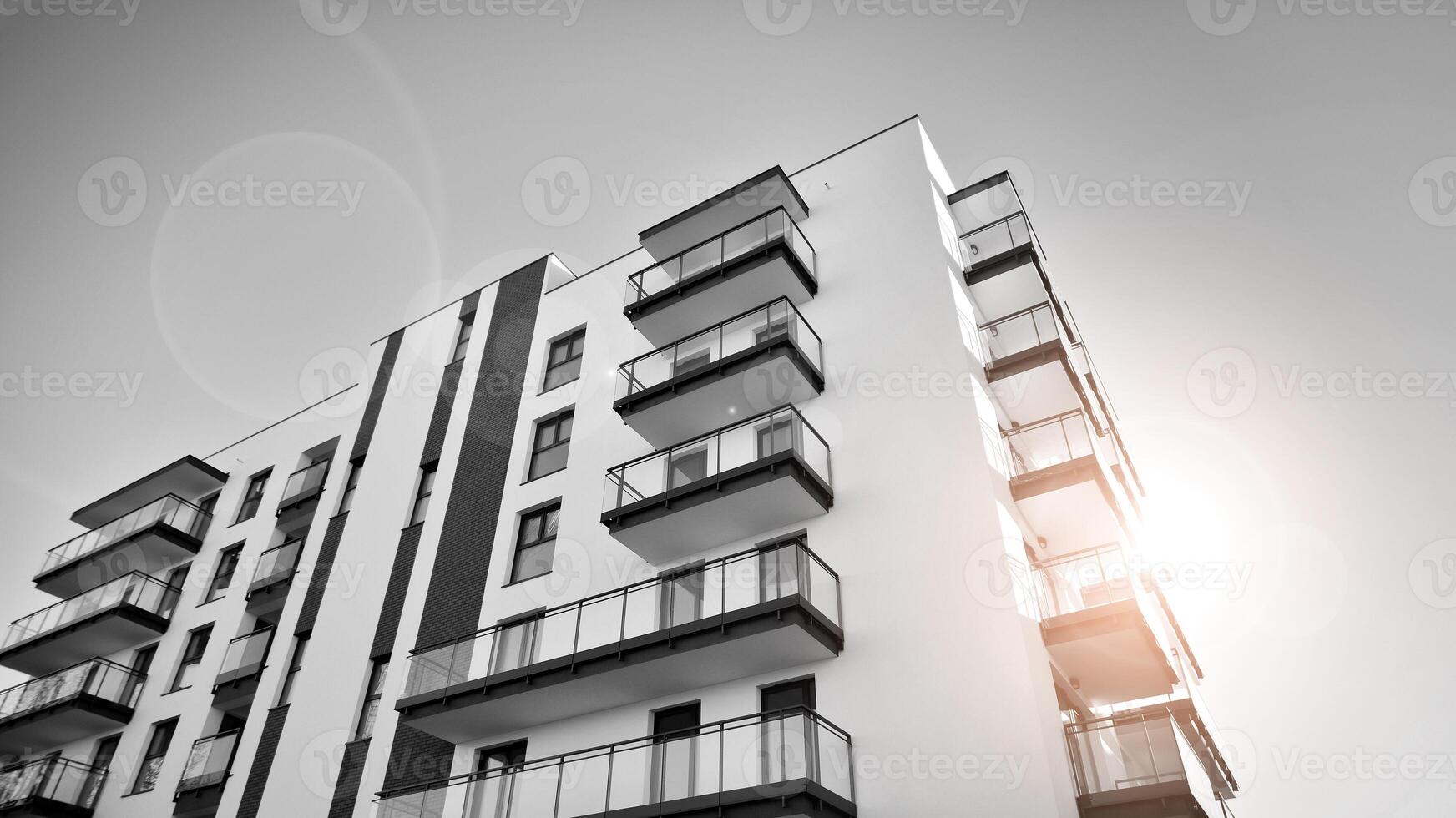 Fragment of a facade of a building with windows and balconies. Modern apartment buildings on a sunny day. Facade of a modern apartment building. Black and white. photo