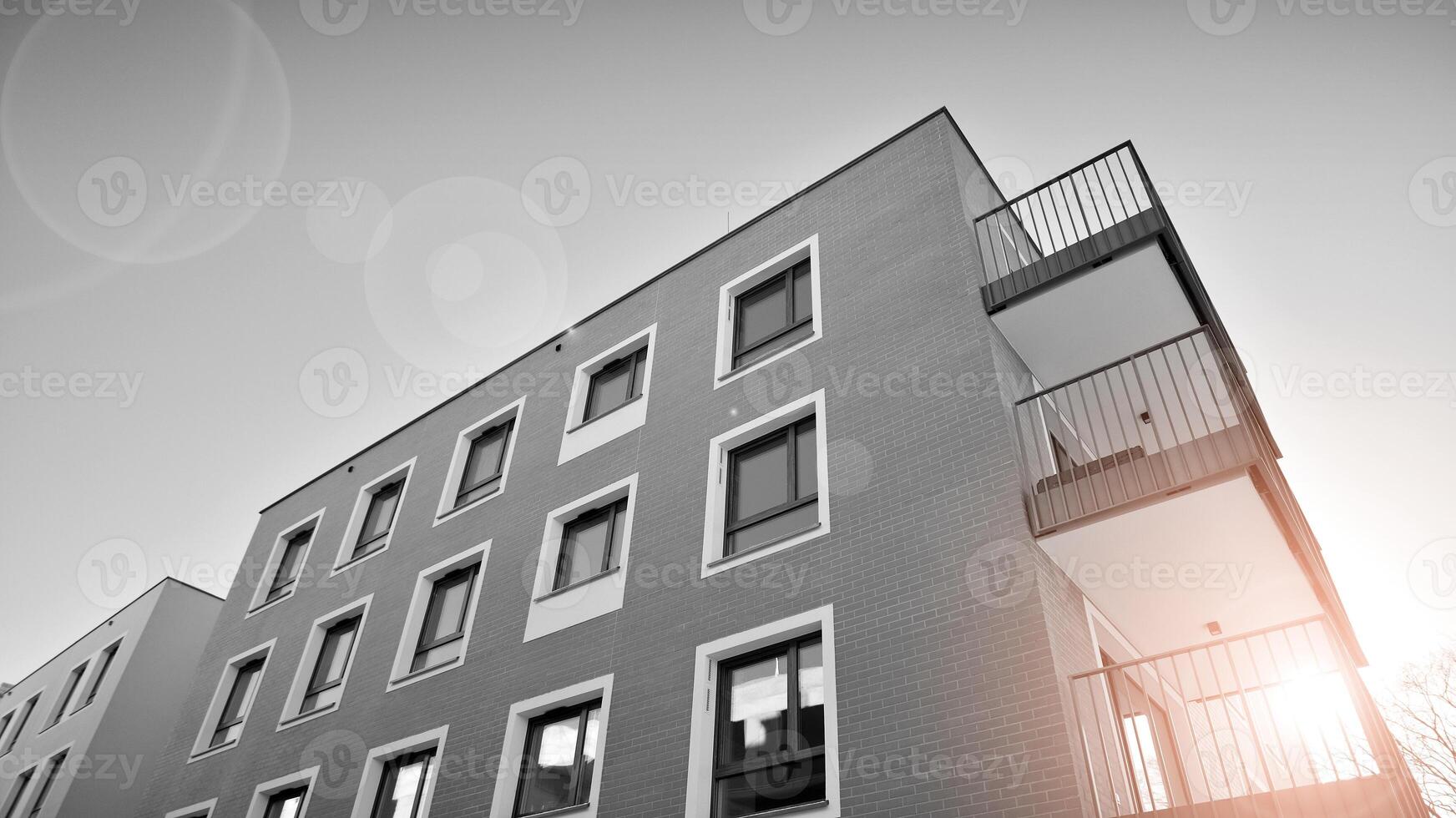 Fragment of a facade of a building with windows and balconies. Modern apartment buildings on a sunny day. Facade of a modern apartment building. Black and white. photo
