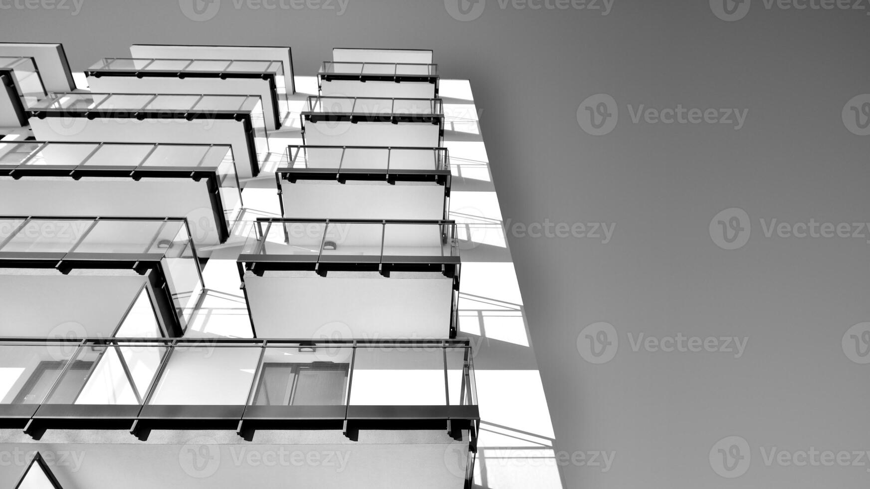 Fragment of a facade of a building with windows and balconies. Modern apartment buildings on a sunny day. Facade of a modern apartment building. Black and white. photo