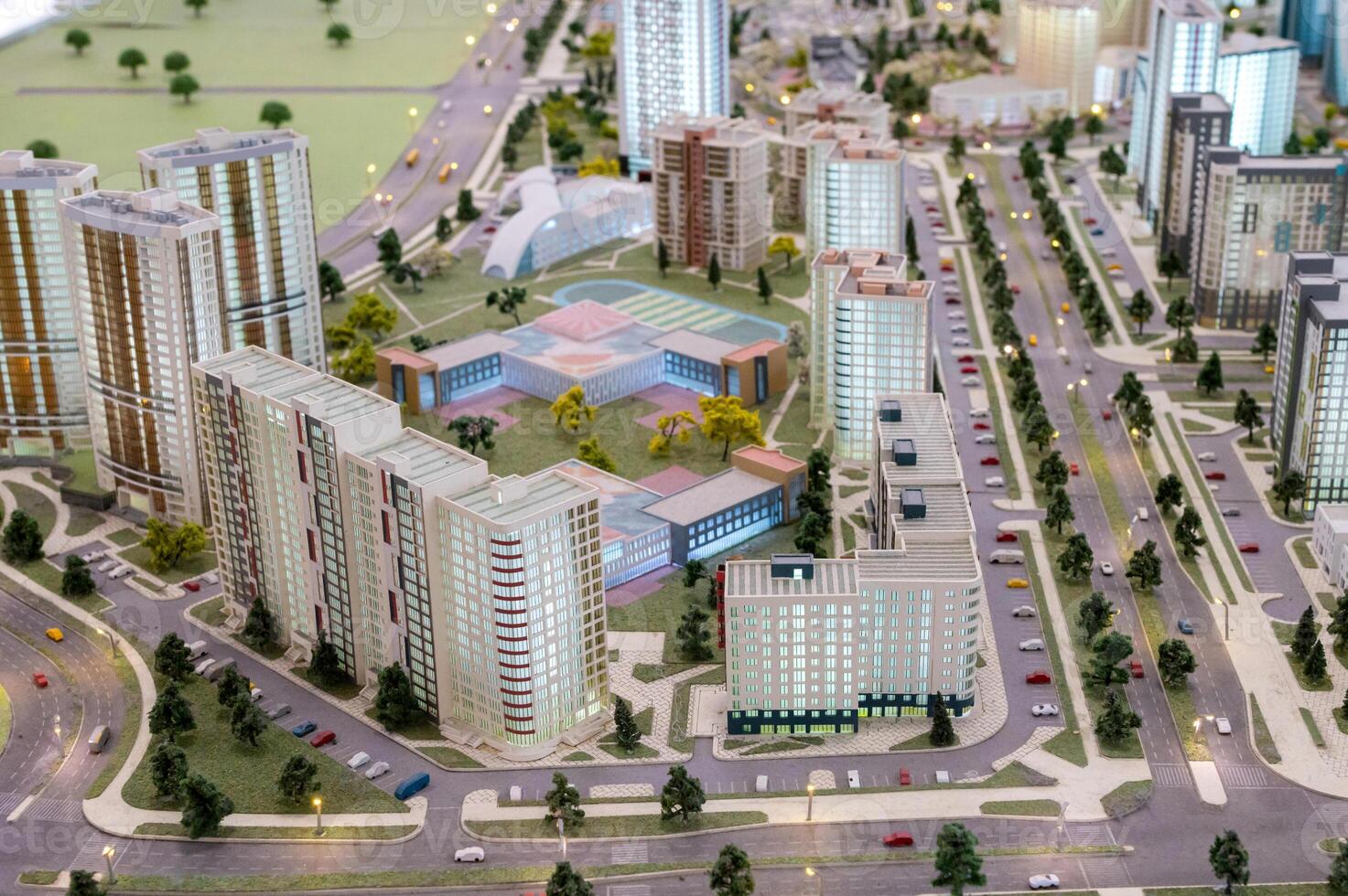 A miniature city on the table. Layout of a block with a residential building and a park. photo