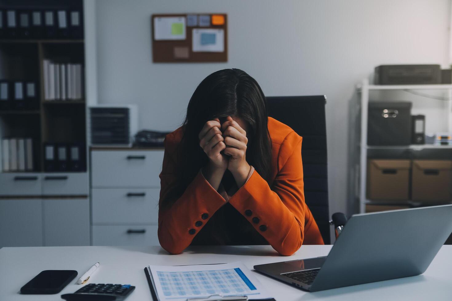 Portrait of tired young business Asian woman work with documents tax laptop computer in office. Sad, unhappy, Worried, Depression, or employee life stress concept photo