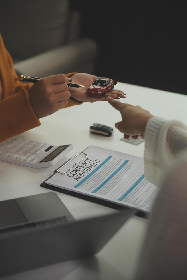 Insurance officers hand over the car keys after the tenant. have signed an auto insurance document or a lease or agreement document Buying or selling a new or used car with a car photo