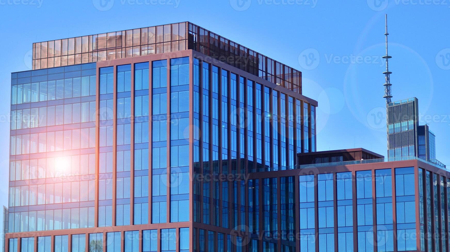 Glass building with transparent facade of the building and blue sky. Structural glass wall reflecting blue sky. Abstract modern architecture fragment. Contemporary architectural background. photo