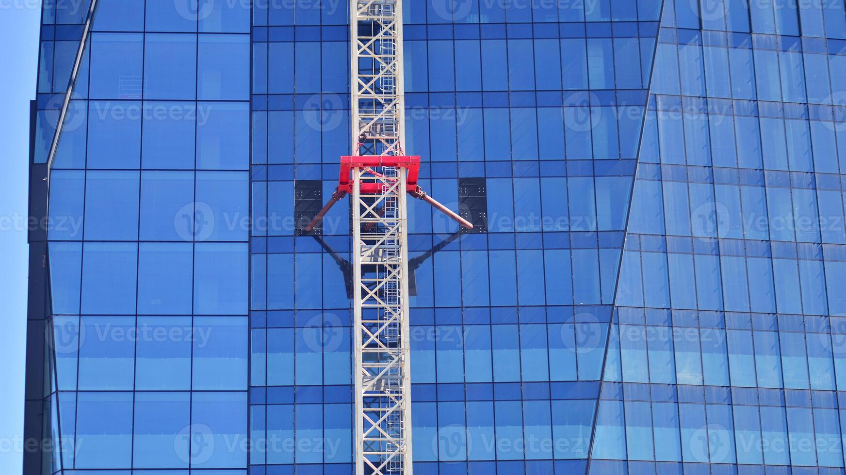 High rise building under construction. Installation of glass facade panels on a reinforced concrete structure. photo