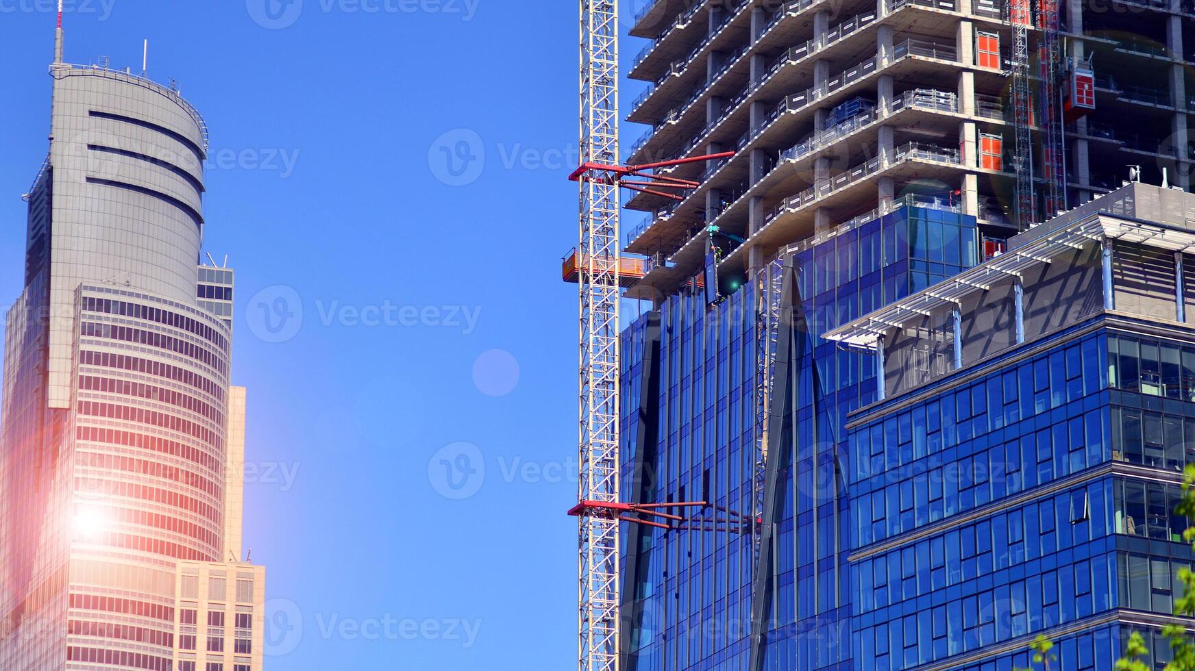 High rise building under construction. Installation of glass facade panels on a reinforced concrete structure. photo
