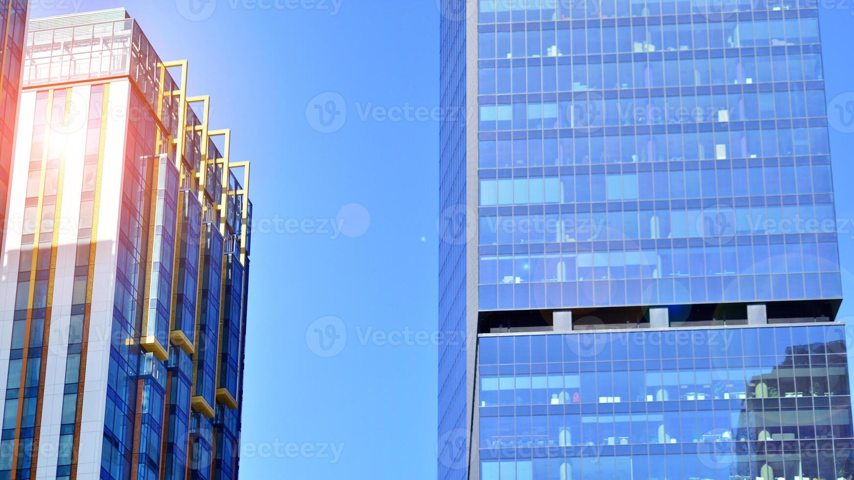 Glass building with transparent facade of the building and blue sky. Structural glass wall reflecting blue sky. Abstract modern architecture fragment. Contemporary architectural background. photo