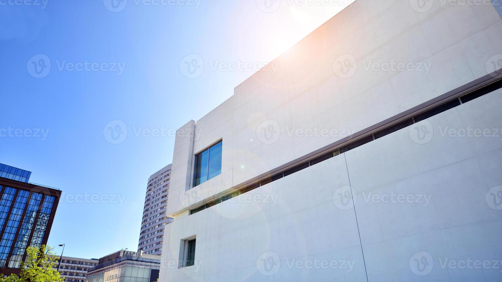 Sunlight and shadow on surface of white Concrete Building wall against blue sky background, Geometric Exterior Architecture in Minimal Street photography style photo