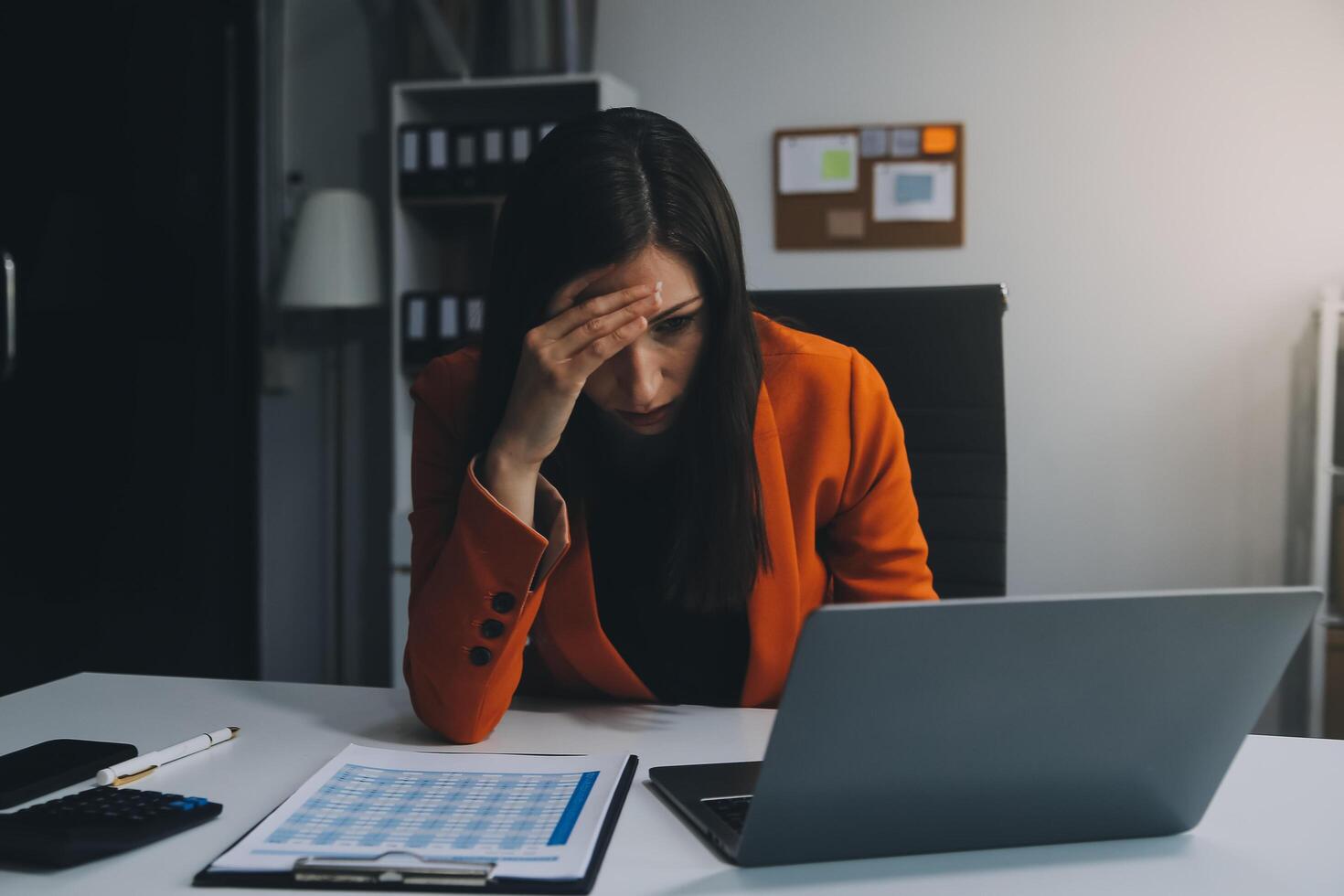 Portrait of tired young business Asian woman work with documents tax laptop computer in office. Sad, unhappy, Worried, Depression, or employee life stress concept photo