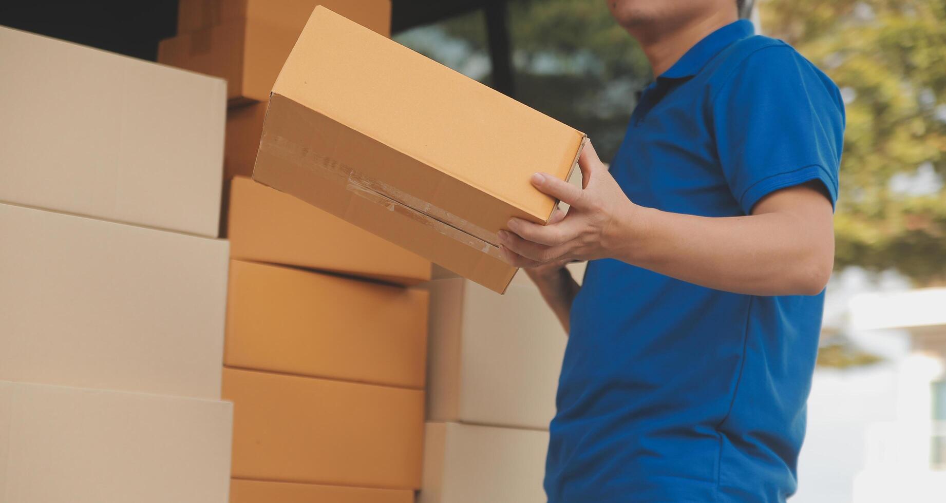 Asian delivery express courier young man use giving boxes to woman customer he wearing protective face mask at front home photo