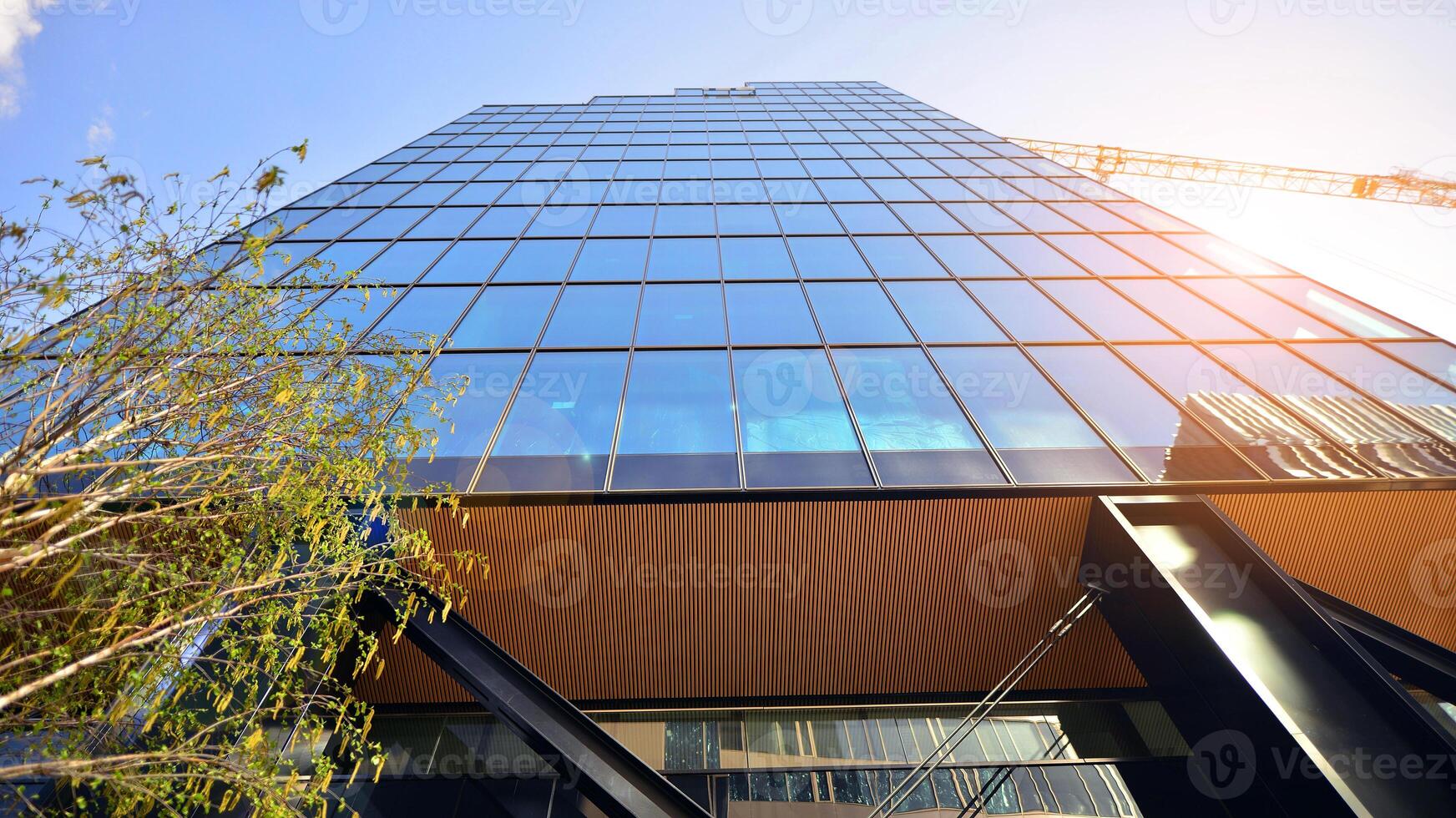 Steel and glass. The subject of modern architecture or construction industry. Modern office building facade with tall steel construction elements and full height windows between. photo