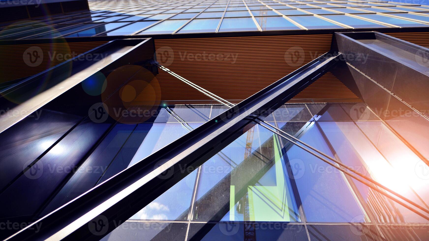 Steel and glass. The subject of modern architecture or construction industry. Modern office building facade with tall steel construction elements and full height windows between. photo