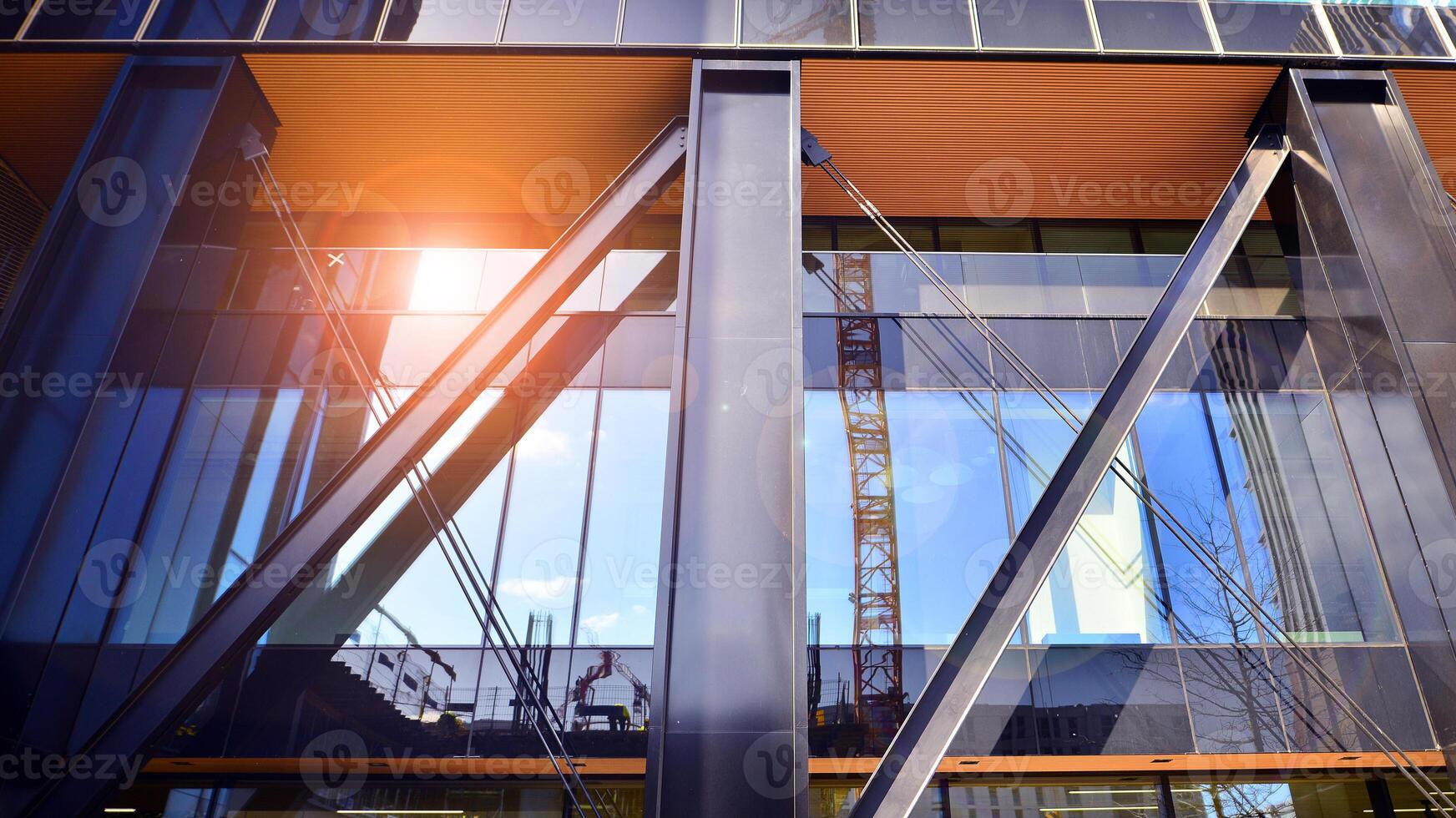 Steel and glass. The subject of modern architecture or construction industry. Modern office building facade with tall steel construction elements and full height windows between. photo