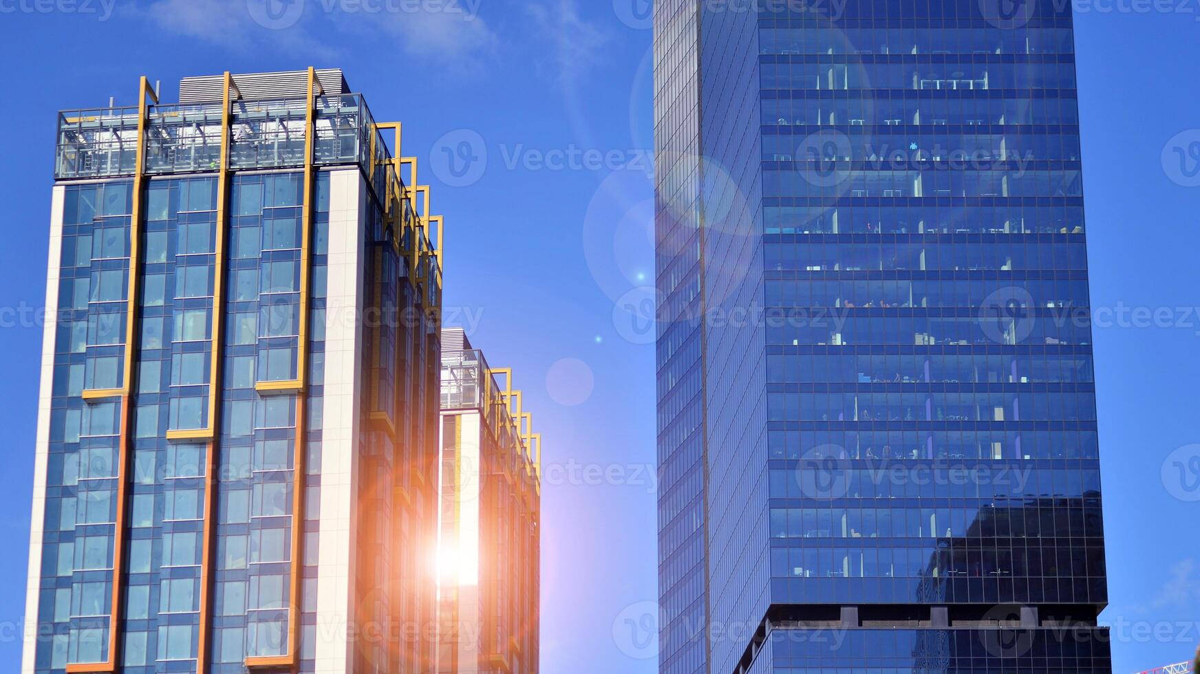Glass building with transparent facade of the building and blue sky. Structural glass wall reflecting blue sky. Abstract modern architecture fragment. Contemporary architectural background. photo