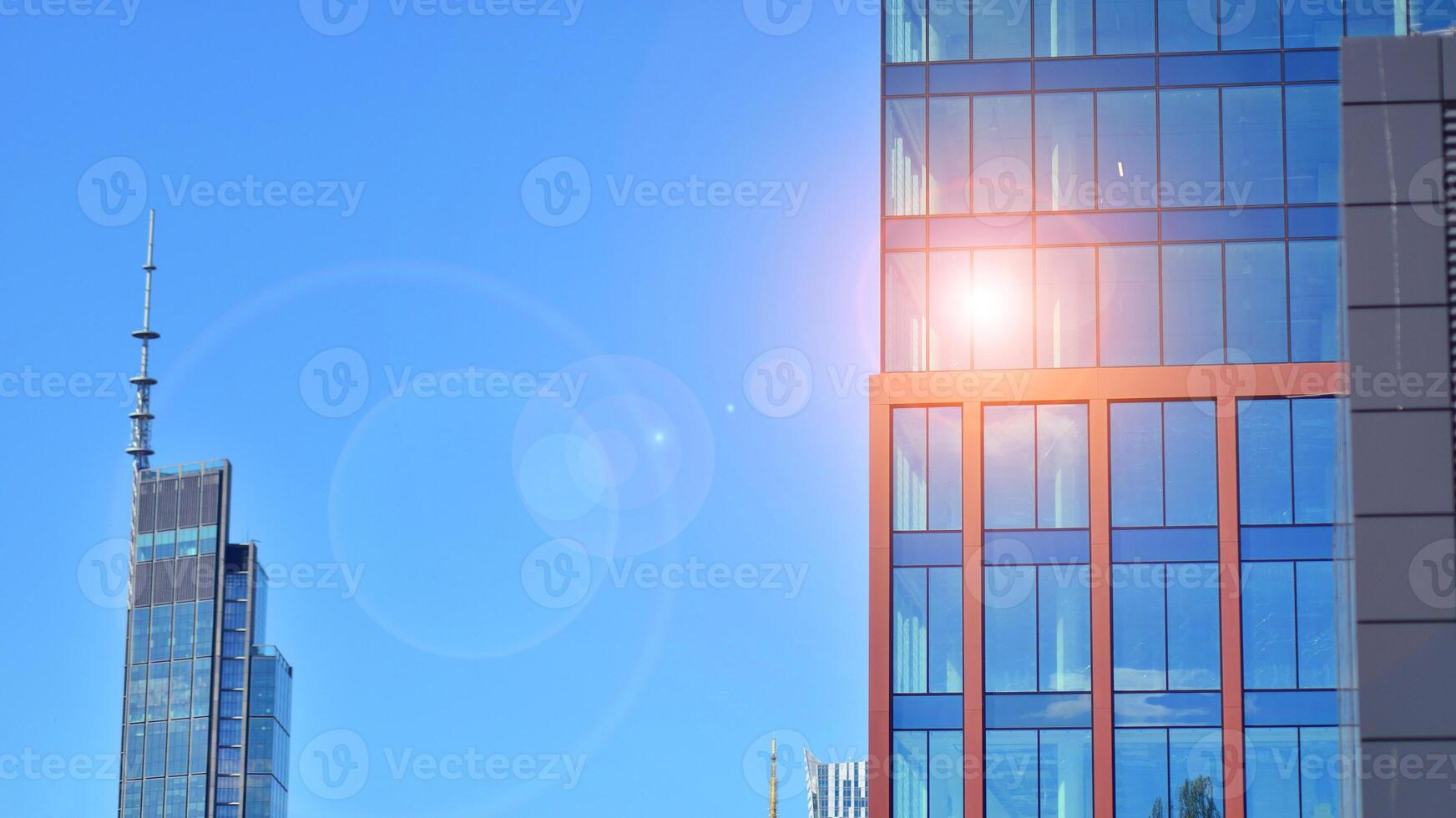 Glass building with transparent facade of the building and blue sky. Structural glass wall reflecting blue sky. Abstract modern architecture fragment. Contemporary architectural background. photo