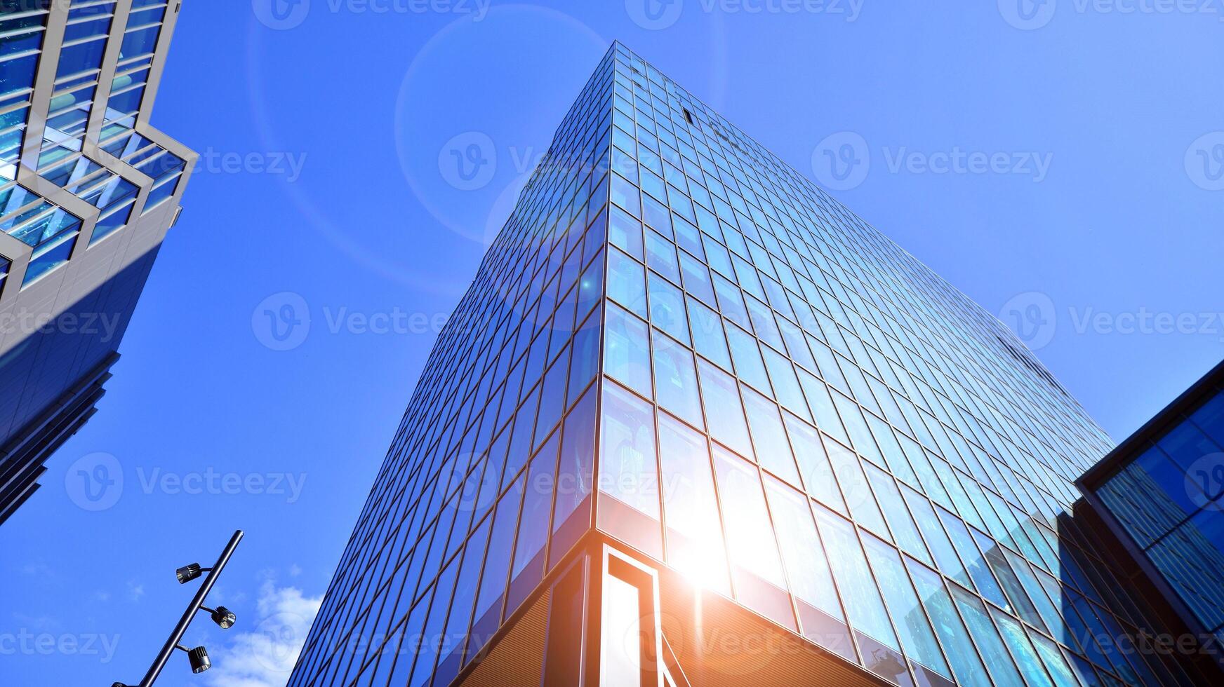 Glass building with transparent facade of the building and blue sky. Structural glass wall reflecting blue sky. Abstract modern architecture fragment. Contemporary architectural background. photo