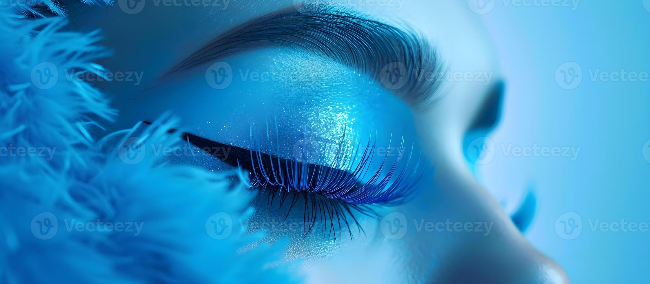 Close-up of woman's eyelashes in blue neon lighting photo