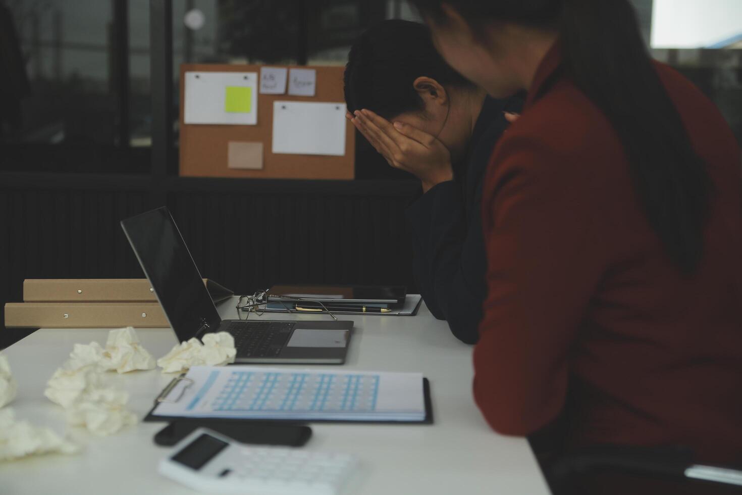 Stressed annoyed office employee manager having headache migraine at business meeting with his colleagues about business problem they have to solve. Stress at work or migraine concept. photo