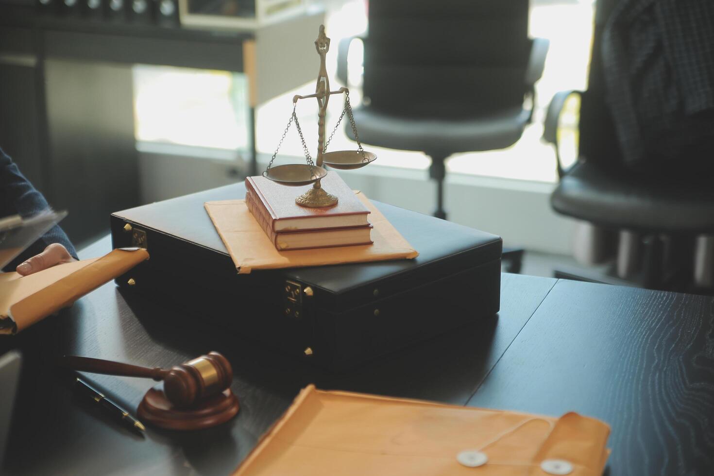 Justice and Law concept. Legal counsel presents to the client a signed contract with gavel and legal law or legal having team meeting at law firm in background photo