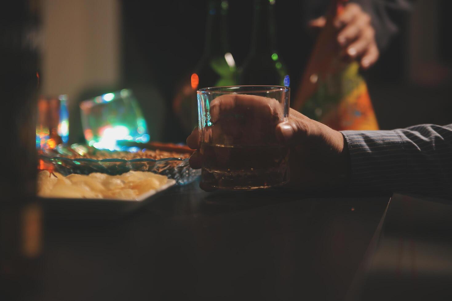 Celebration night, pour whiskey into a glass. Give to friends who come to celebrate photo