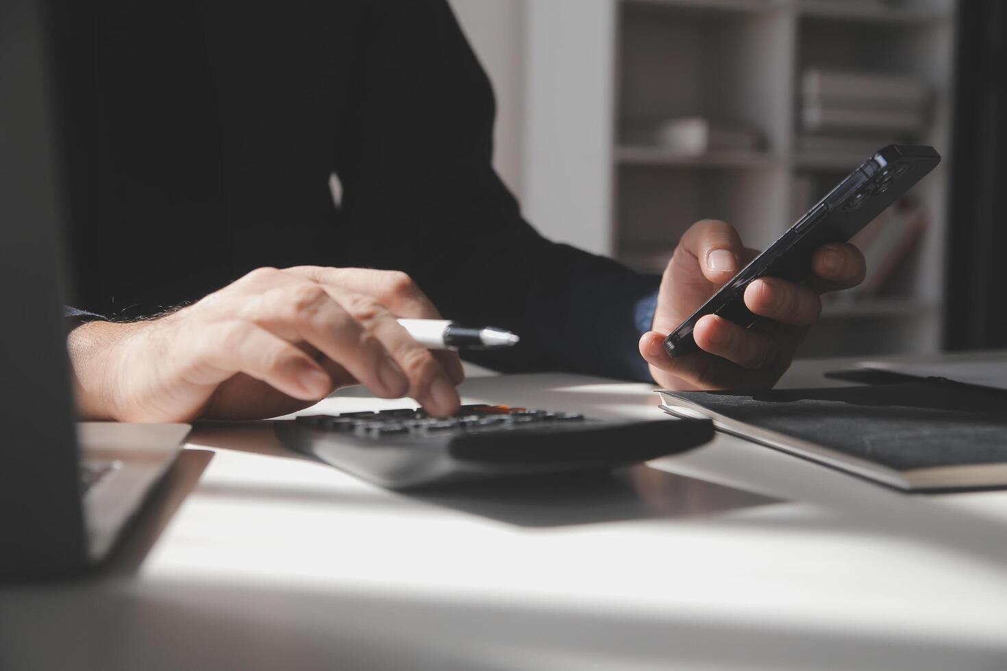 businessman working on desk office with using a calculator to calculate the numbers, finance accounting concept photo