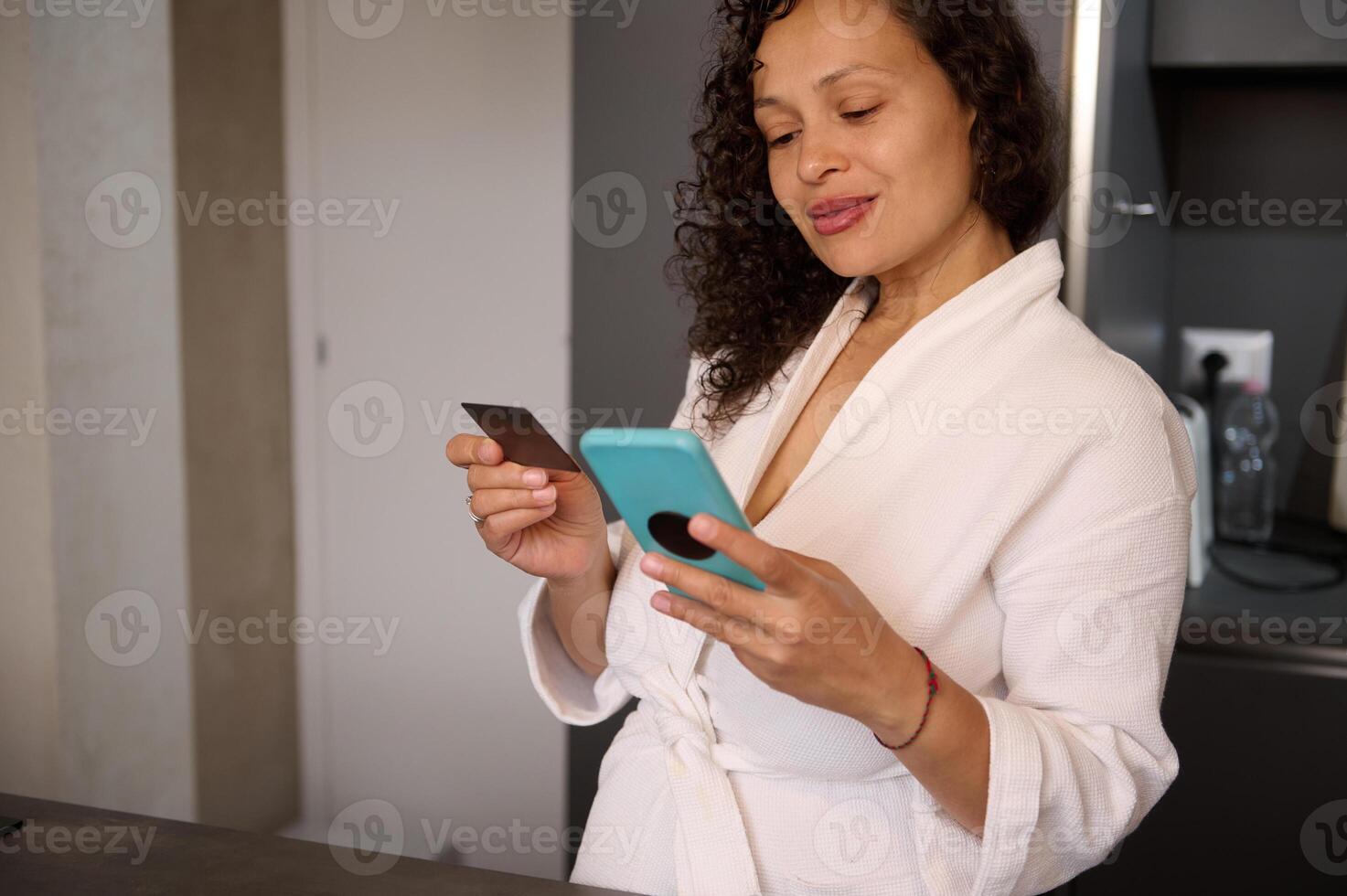Young pretty woman holding mockup blank mobile phone screen, scanning a black empty credit card for making online payments via internet banking. People. Internet, Online communication. Connection photo
