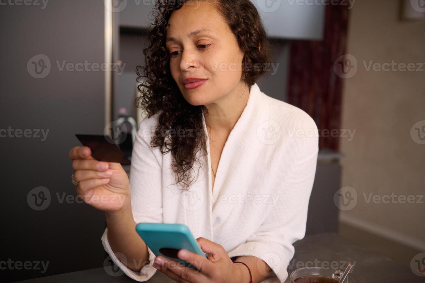 Attractive woman at home holding black credit card and smartphone, booking hotel, ordering food, transferring money via internet banking, making payment, using mobile app. Copy advertising space photo