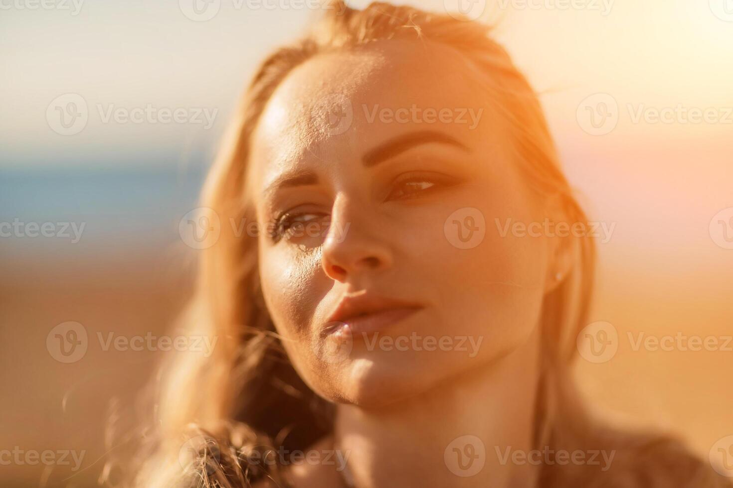 Portrait blonde sea cape. A calm young blonde in an unbuttoned khaki raincoat stands on the seashore, under the raincoat there is a black skirt and top photo