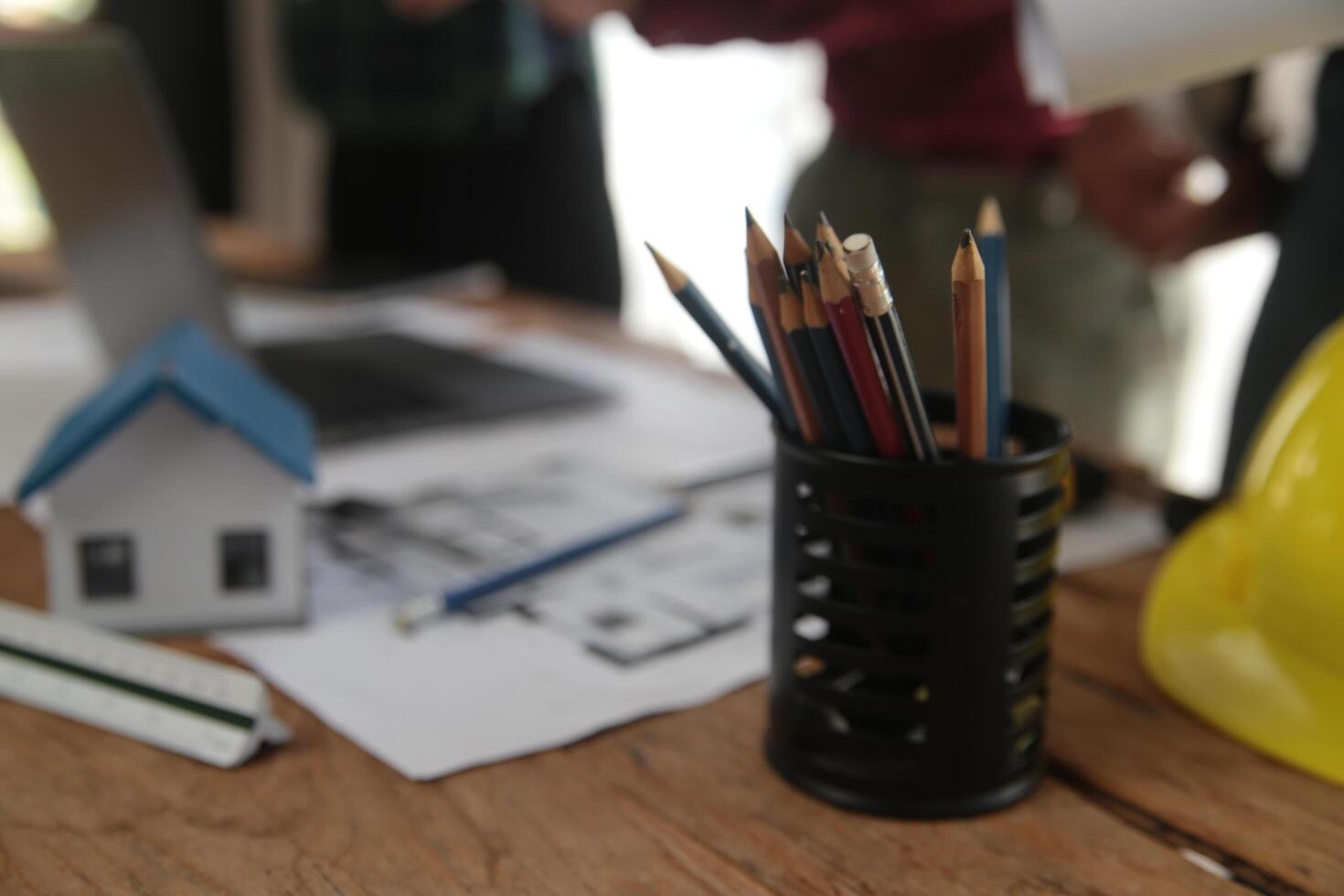 Engineers are consulting the team to design an architectural structure for clients with blueprints and building models to work at office. photo
