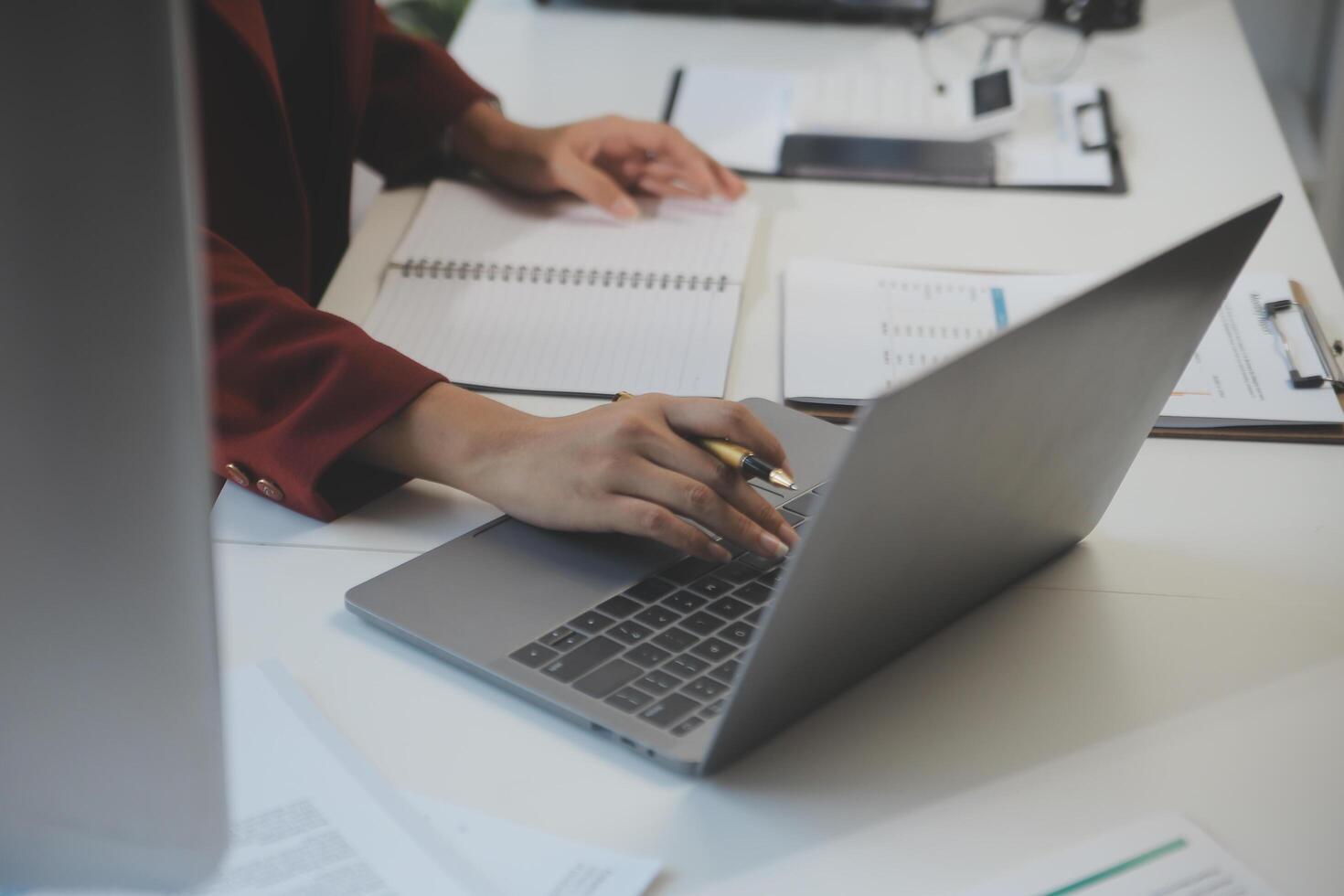Cropped image of professional businesswoman working at her office via laptop, young female manager using portable computer device while sitting at modern loft, flare light, work process concept photo